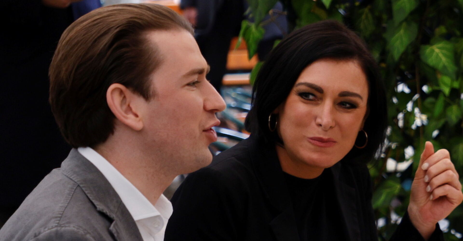 Elisabeth Köstinger schaut Sebastian Kurz an. Die beiden sitzen in einem Gastgarten und plaudern.