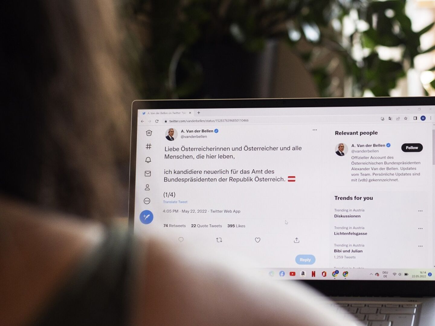 Eine Frau sitzt vor einem Laptop, man sieht ihr über die Schulter. Auf dem Bildschirm der Wahlkampfaccount von Alexander Van der Bellen. In einem Tweet verkündet er seine Wiederkandidatur
