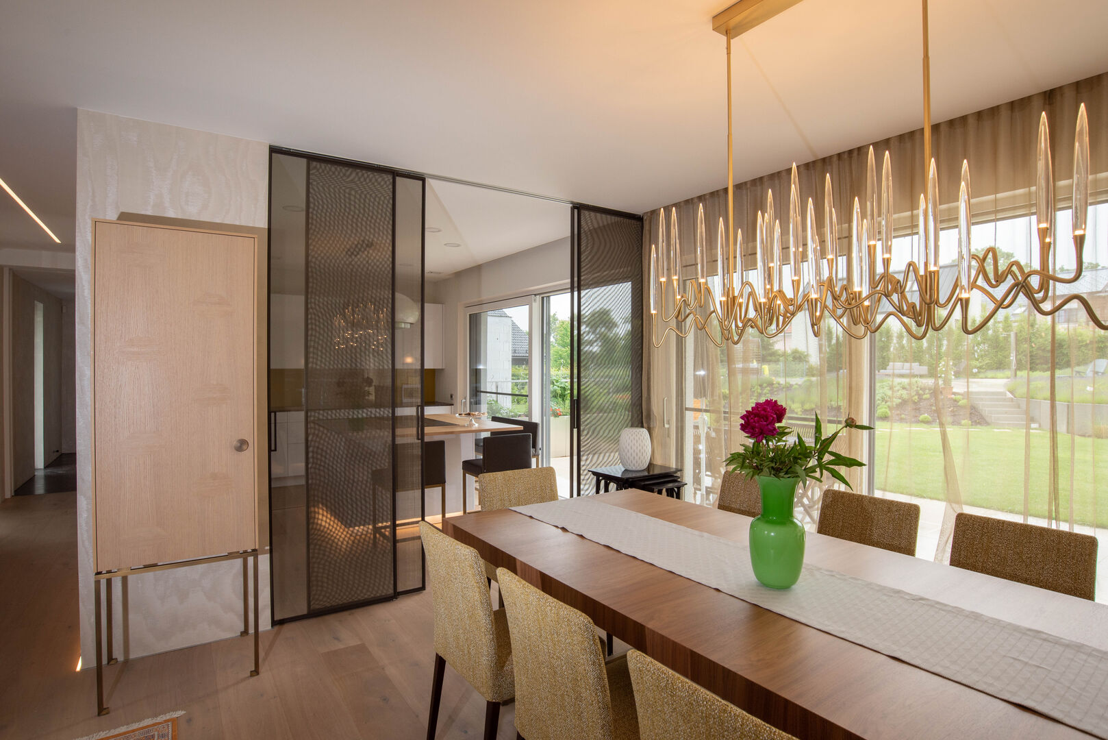 Goldener Wohnzimmerleuchter über dem Tisch | Credit: Elke Altenberger Interior Design Consulting