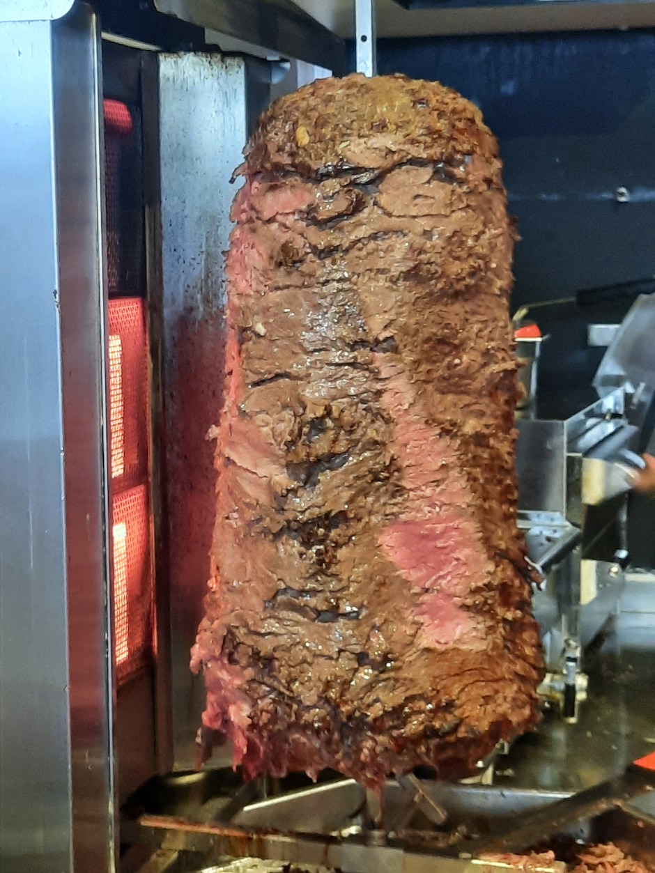 Ein Dönerspieß, frisch angeschnitten. Das Fleisch ist innen zartrosa
