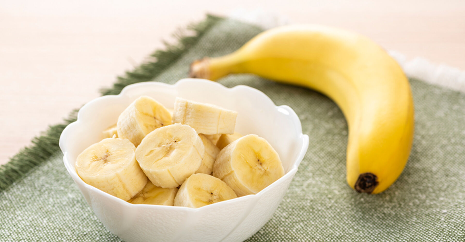 Eine Schüssel mit einer aufgeschnittenen Banane und einer weiteren daneben | Credit: iStock.com/kuppa_rock