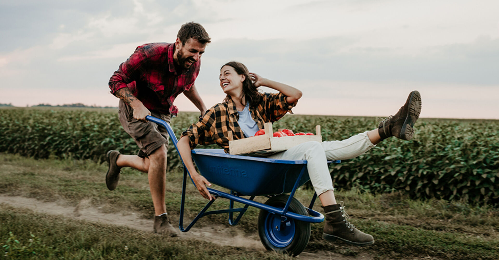 Verliebter Mann schiebt seine Freundin im Schubkarren vor sich her | Credit: iStock.com/Studio4