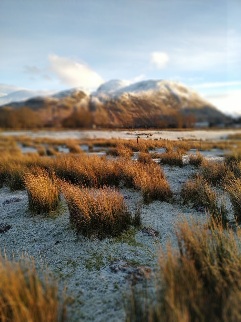 Verschneite Gebirgslandschaft in Schottland an einem sonnigen Wintertag | Credit: iStock.com/rob2211