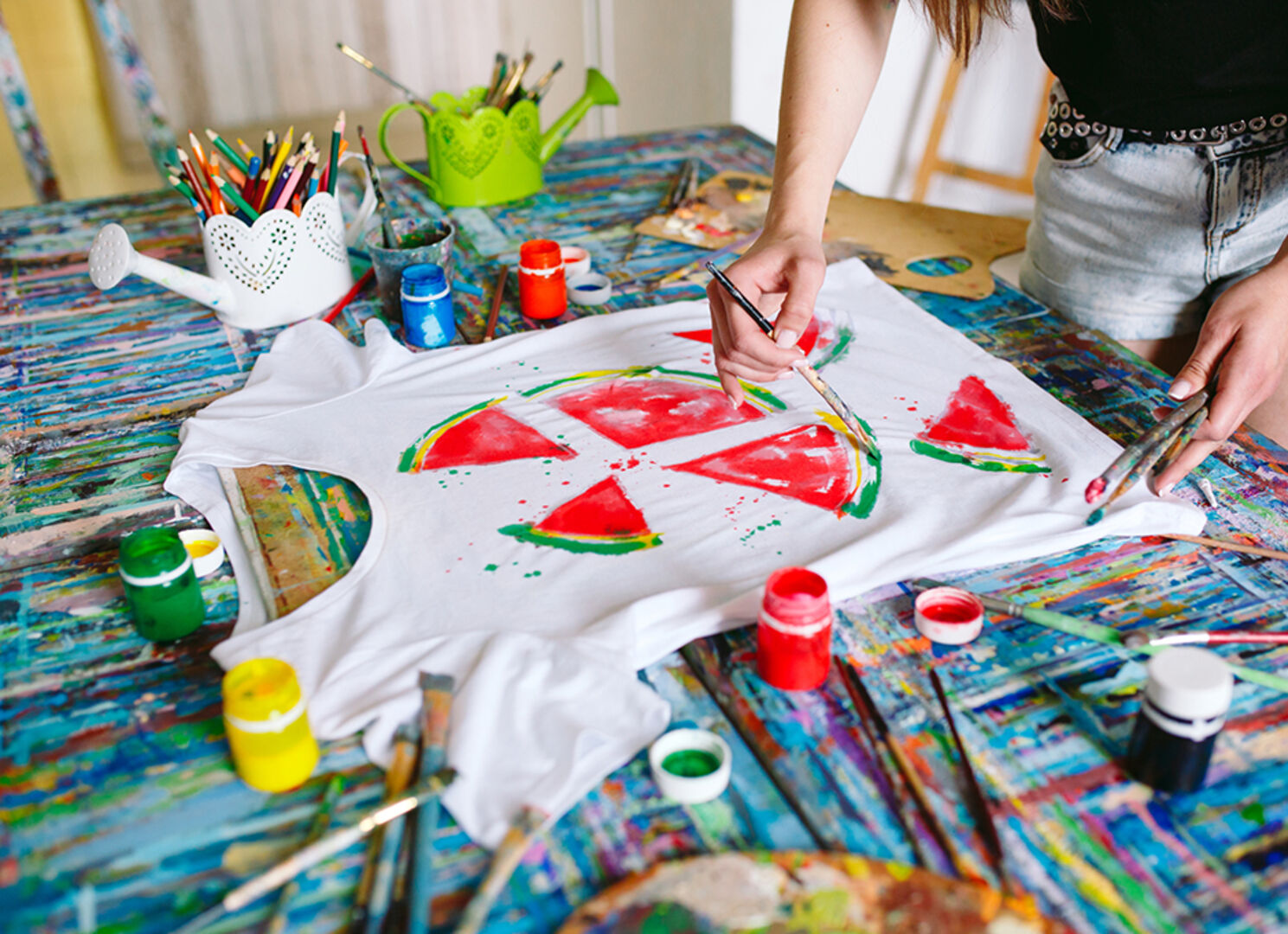 Junge Frau bemalt ihr T-Shirt | Credit: iStock.com/davit85