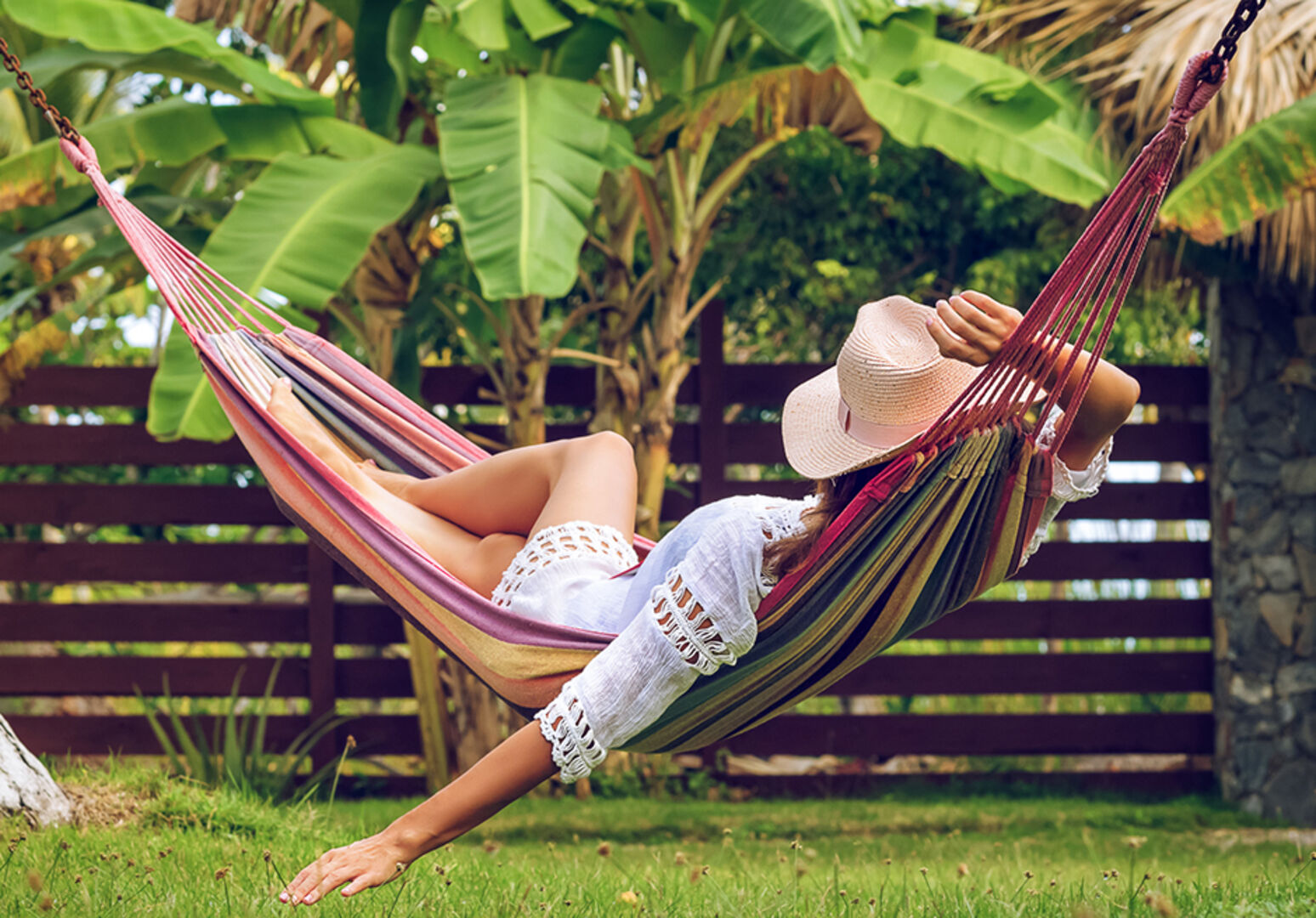 Junge Frau in ihrer Hängematte im Garten | Credit: iStock.com/StudioMikara