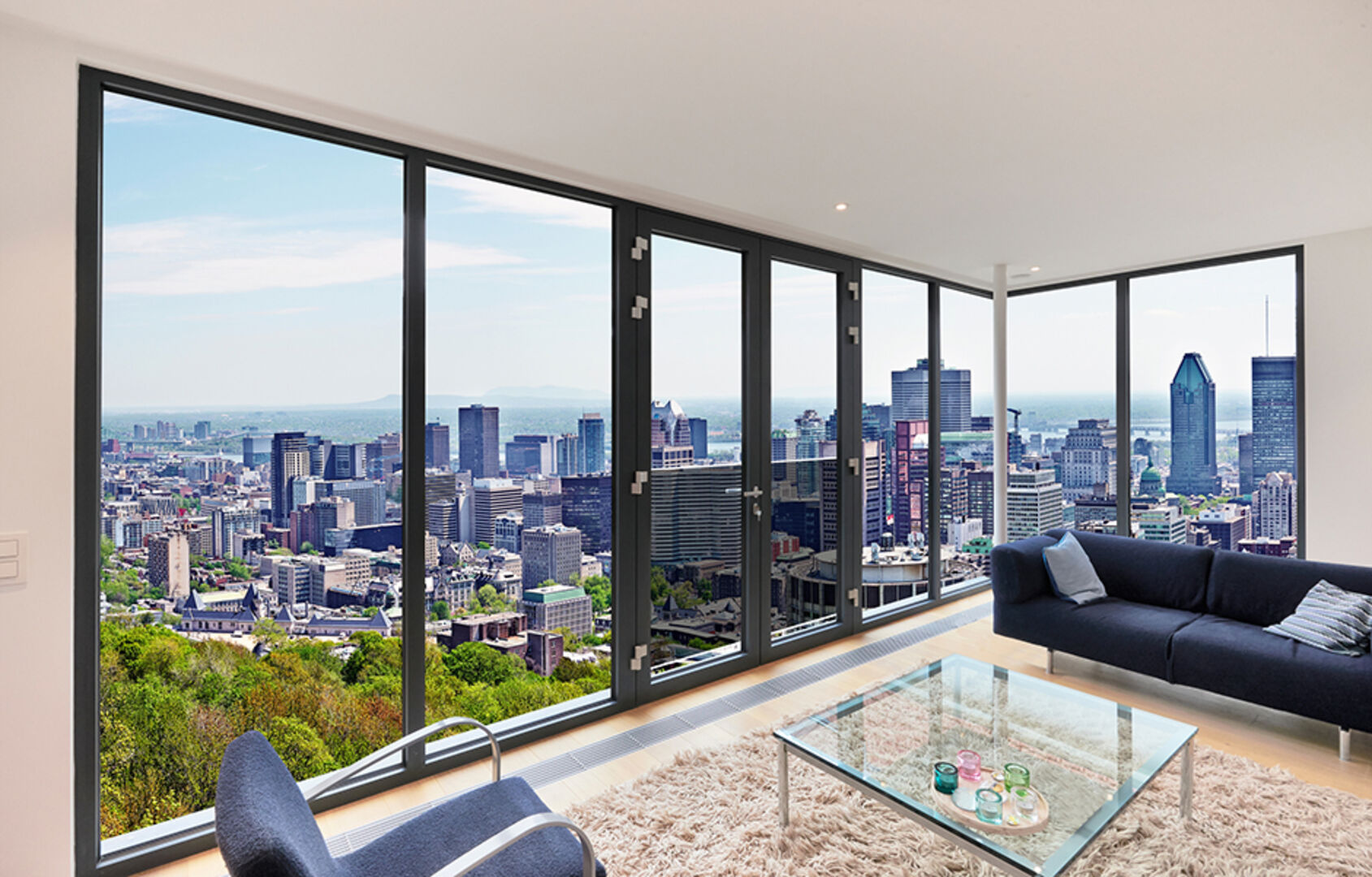 Wandhohe Fenster eines Hochhauses, die einen atemberaubenden Blick auf die umliegende Skyline ermöglichen | Credit: iStock.com/Bombaert