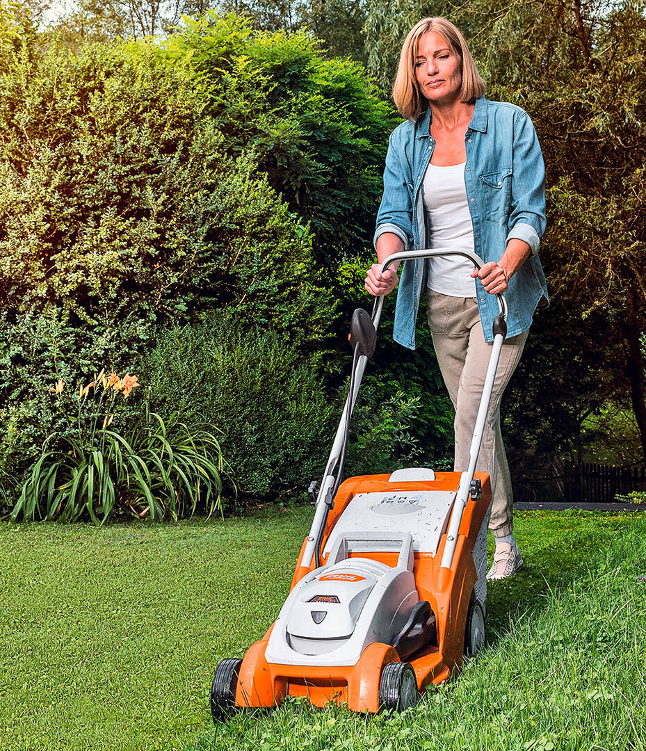 Frau bei der Gartenarbeit mit einem Akku-Rasenmäher von STIHL | Credit: ZGONC