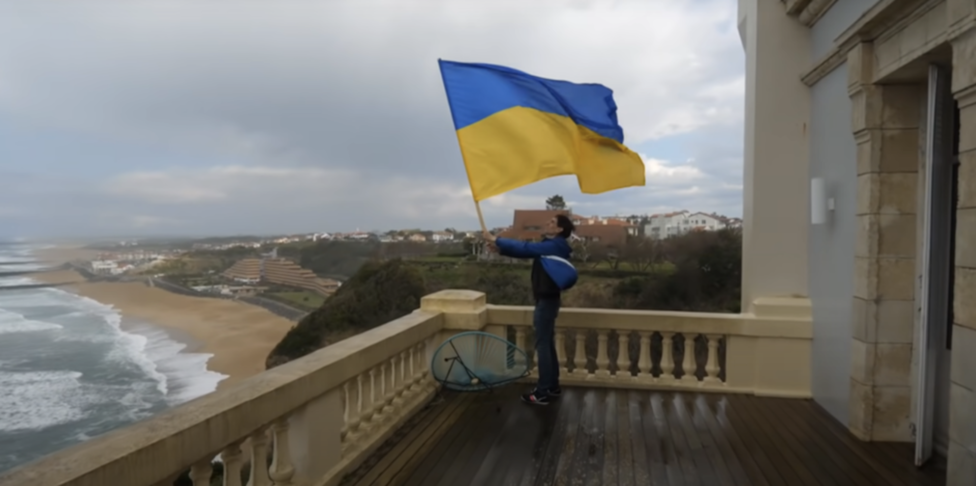 Mann mit Ukraineflagge auf Terrase