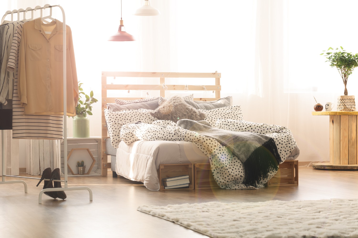 Bett und Kleiderstange im Schlafzimmer | Credit: iStock.com/KatarzynaBialasiewicz