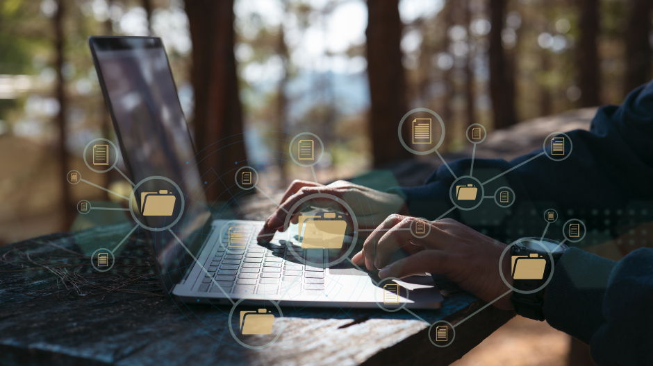 Junger Mann sitzt im Wald und tippt auf seinem Notebook | Credit: iStock.com/ipuwadol