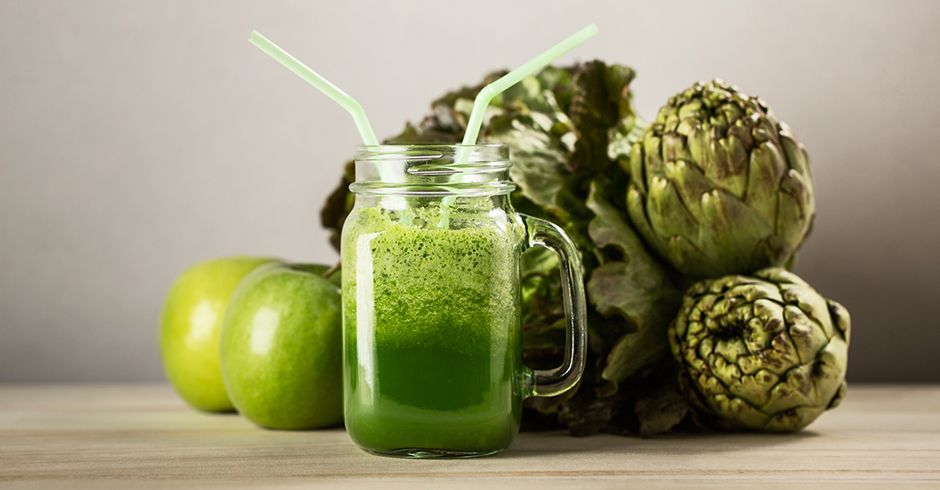 Artischocken und Äpfel arrangiert um einen grünen Smoothie | Credit: iStock.com/alexsalcedo