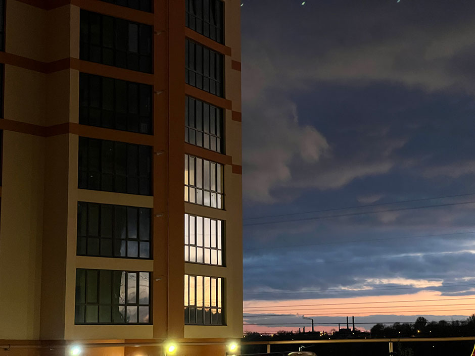 Modernes Hochhaus mit glitzernden Glasfassaden in der Dämmerung | Credit: iStock.com/Igor Ploskin