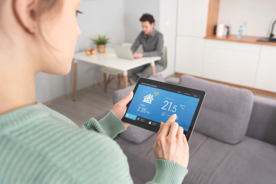 Junge Frau steuert ihre Klimaanlage via Smart Home App | Credit: iStock.com/simpson33