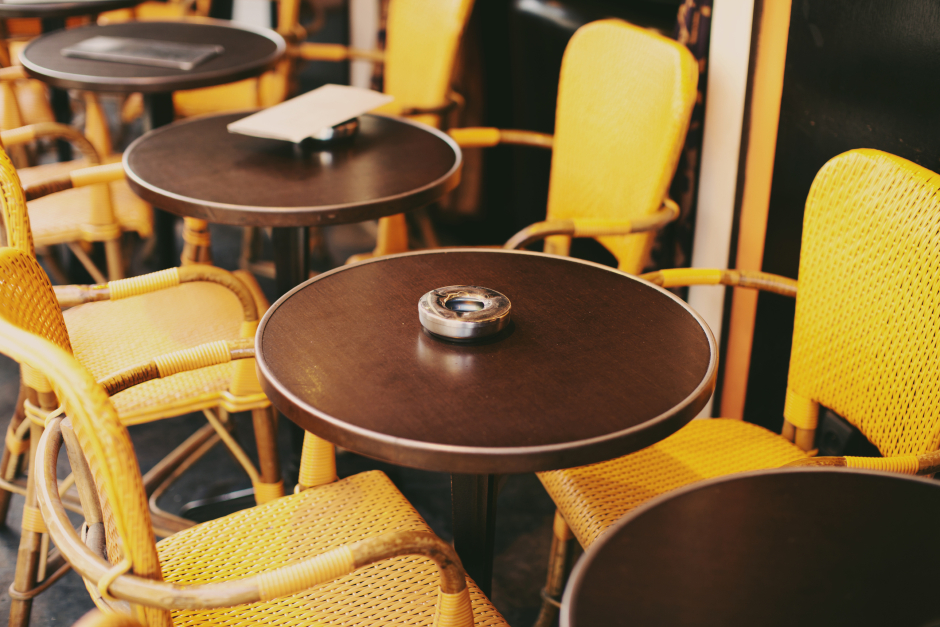 Tische und Stühle eines französischen Straßencafés | Credit: iStock.com/doisneau