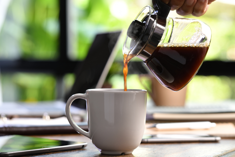 Eine junge Frau schenkt eine Tasse Kaffee ein | Credit: iStock.com/amenic181