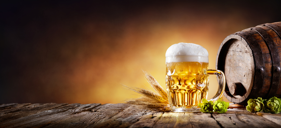 Ein Krügerl Bier neben einem Holzfass | Credit: iStock.com/RomoloTavani