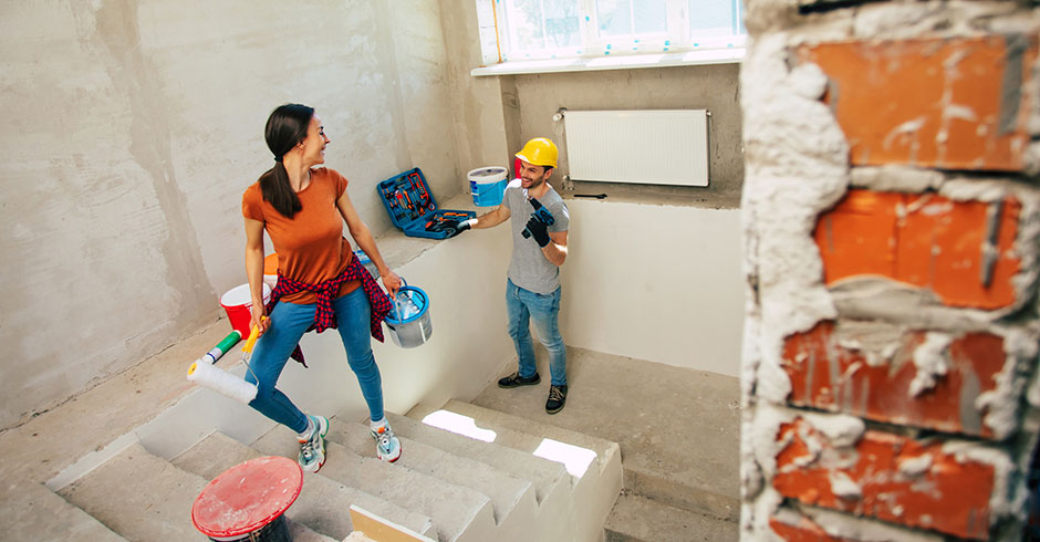 Junges Paar bei der Arbeit in ihrem Rohbau | Credit: iStock.com/Povozniuk