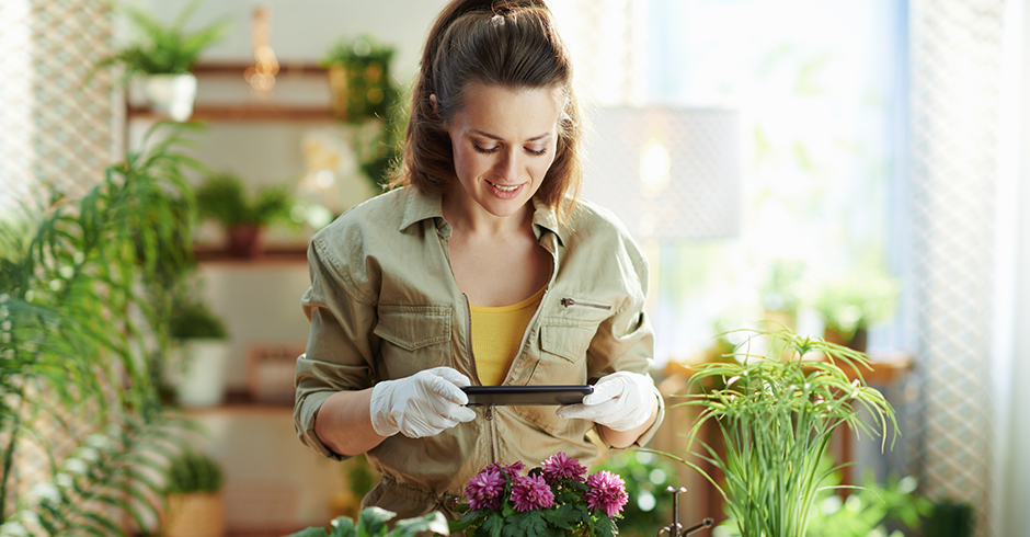 Junge Frau pflegt ihre Zimmerpflanzen | Credit: iStock.com/CentralITAlliance