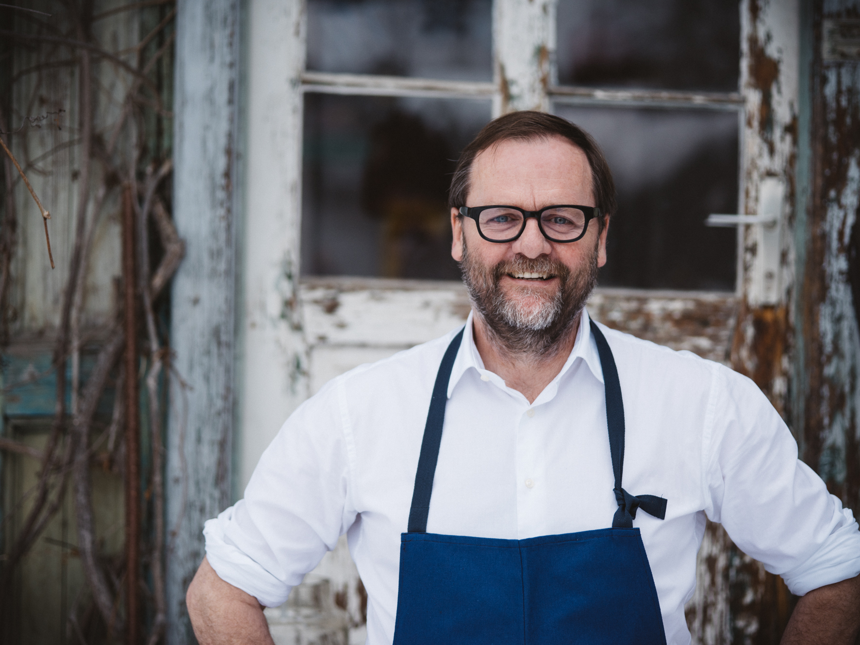 Gastronom Sepp Schellhorn mit weißem Hemd und blauer Schürze