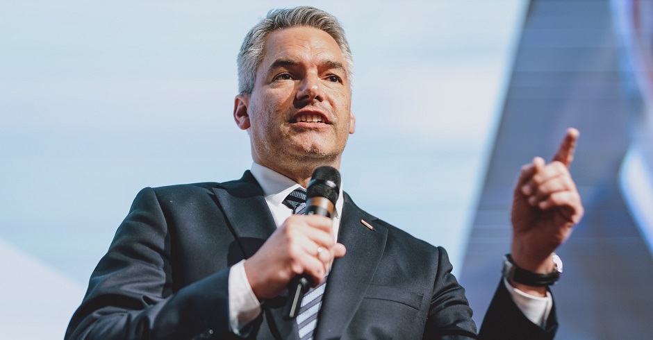 Karl Nehammer auf der Bühne des Tiroler Landesparteitags. Er hält ein Mikrofon in der Hand und hat den Zeigefinger in der Luft erhoben