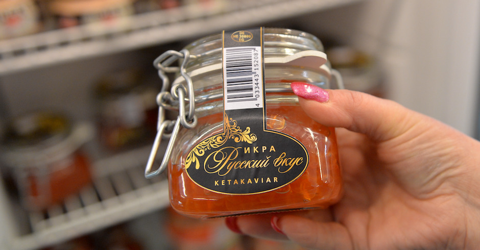 Frauenhand hält Glas mit orangem Inhalt