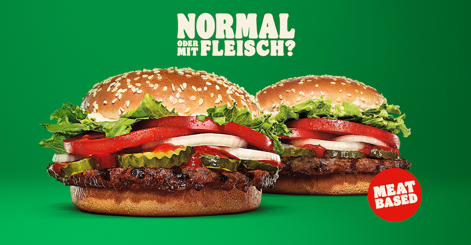 Ein Werbeplakat mit zwei Burgern. Darüber der Schriftzug: &quot;Normal oder mit Fleisch&quot;
