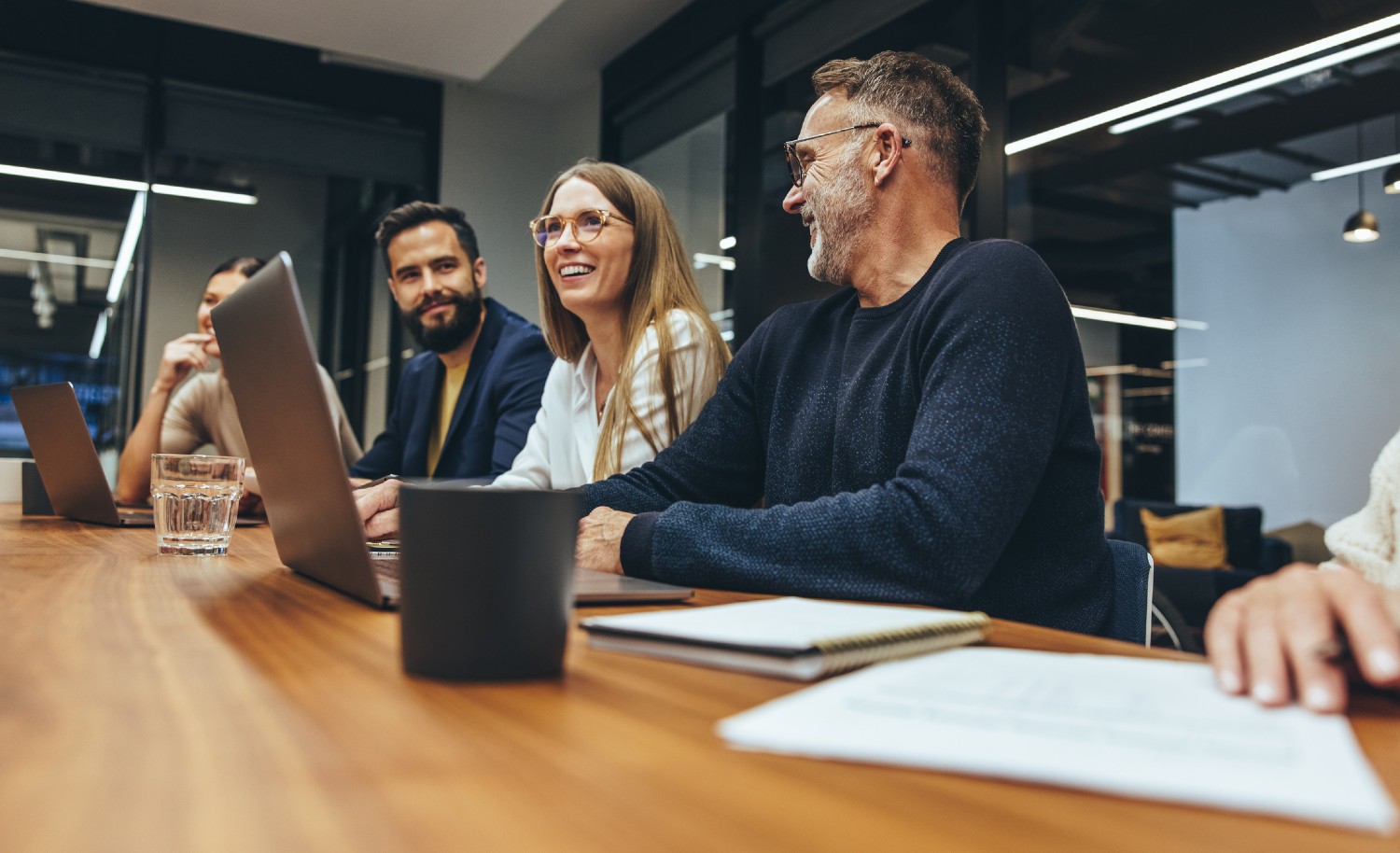 Mitarbeiter sitzen gemeinsam am Bürotisch | Credit: iStock.com/jacoblund