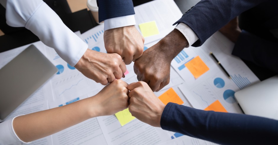 Viele Mitarbeiter bezeugen ihre Teamstärke mit Faustschlag | Credit: iStock.com/fizkes