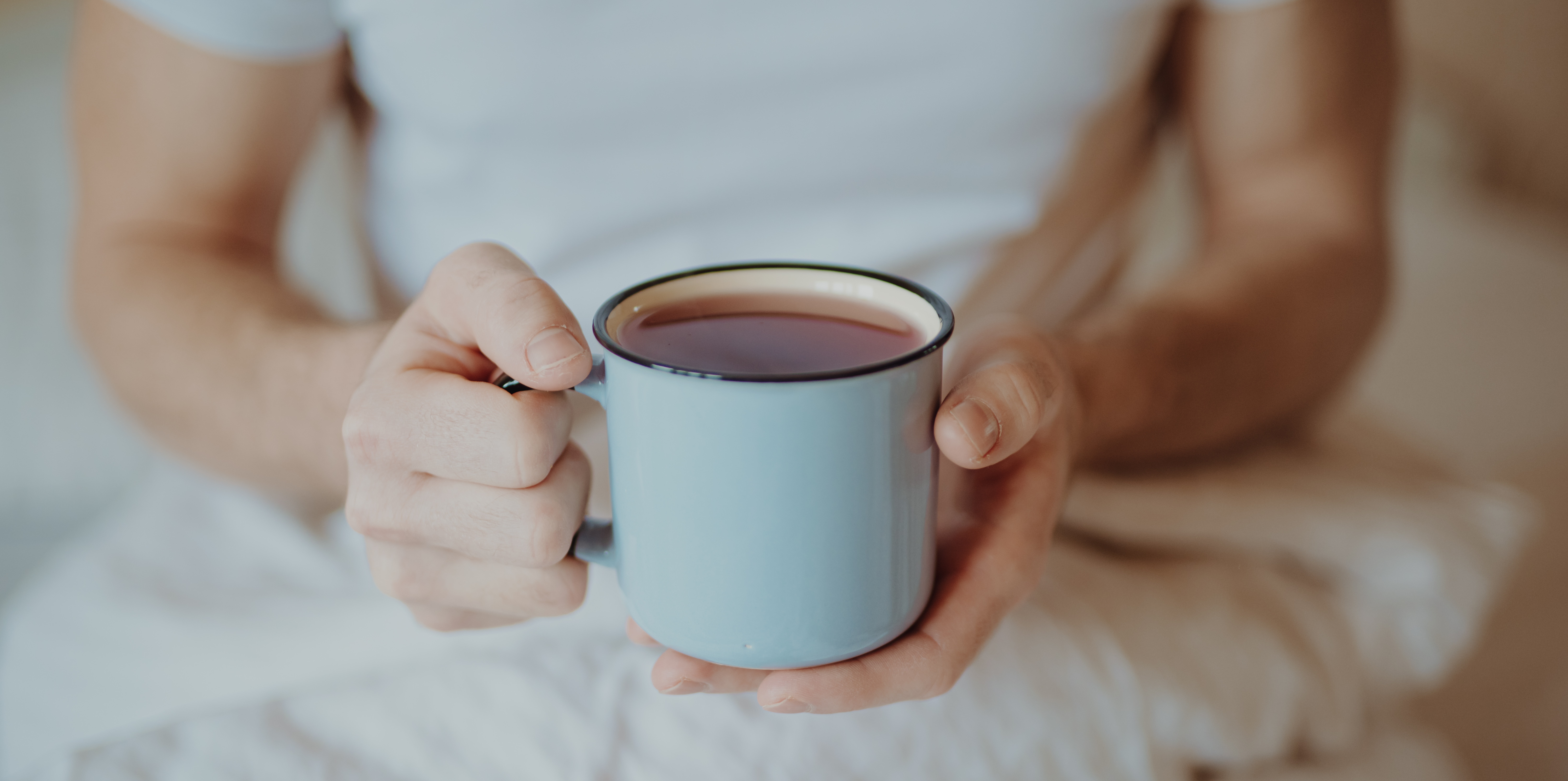 Mann hält hellblaue Teetasse | Credit: iStock.com/AntGor