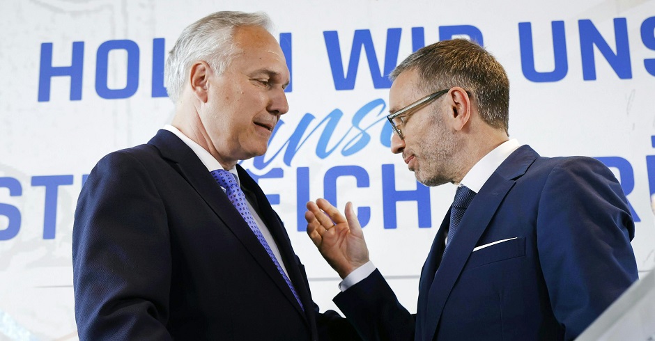 Walter Rosenkranz und Herbert Kickl im Gespräch vor einer Wand mit dem Schriftzug: &quot;Holen wir uns Österreich zurück&quot;