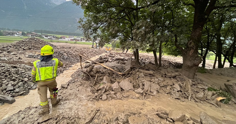 Eine Mure ist abgegangen. Ein Feuerwehrmann steht im Schlamm