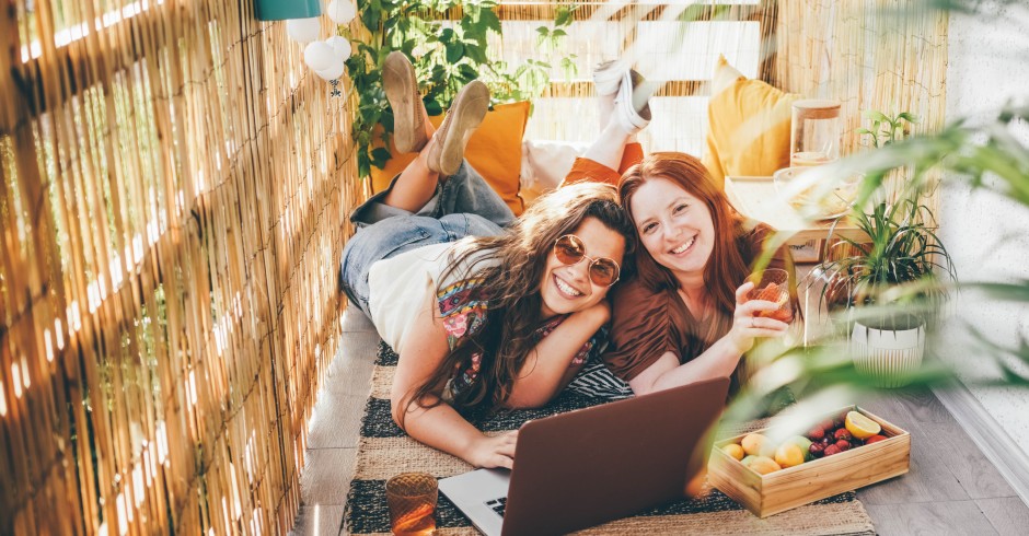 Zwei Mädchen liegen auf einem Balkon | Credit: iStock.com/Maria Korneeva