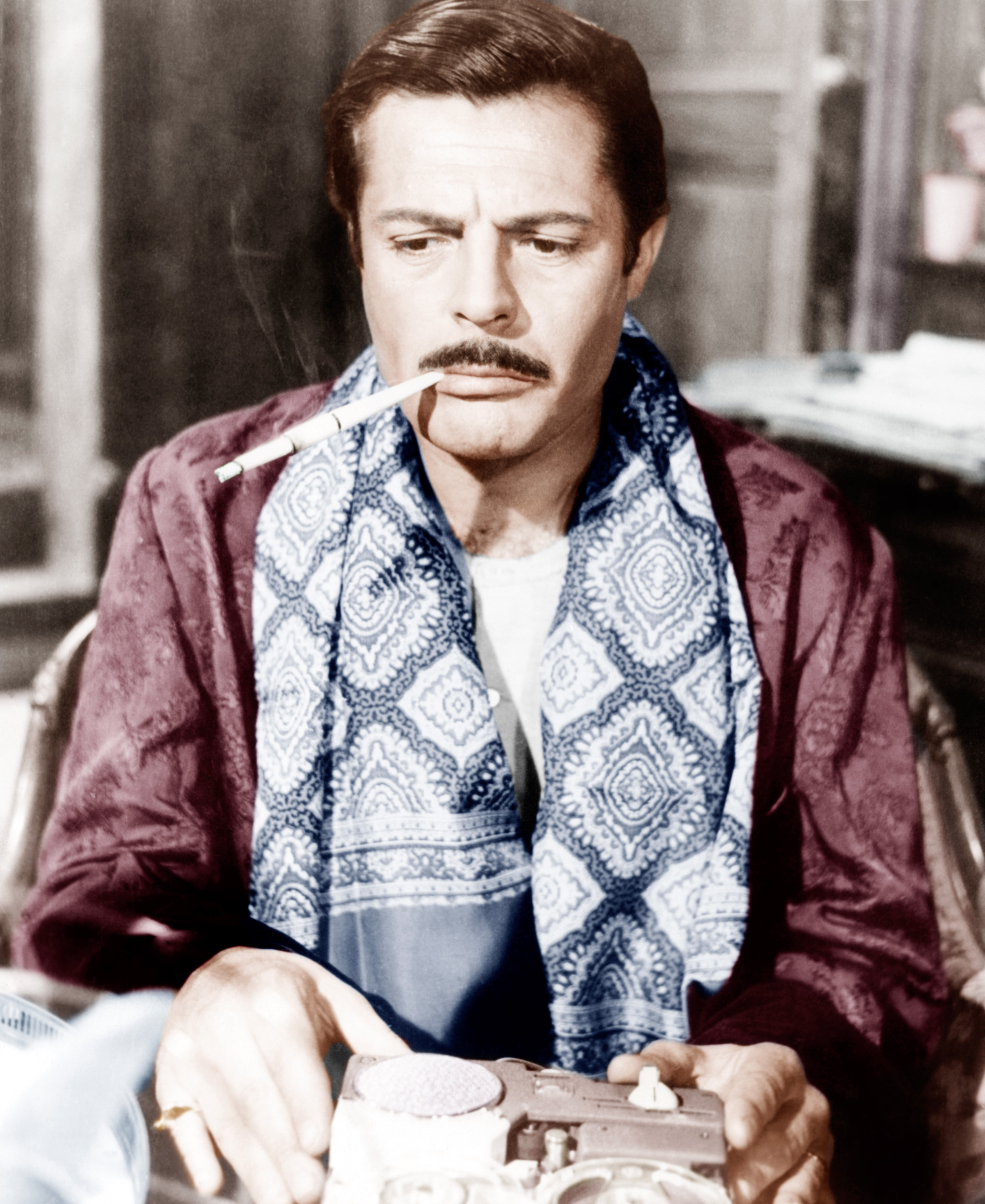 Filmaufnahme von Marcello Mastroianni mit Schurrbart und einem Zigarettenspitz im Mund.