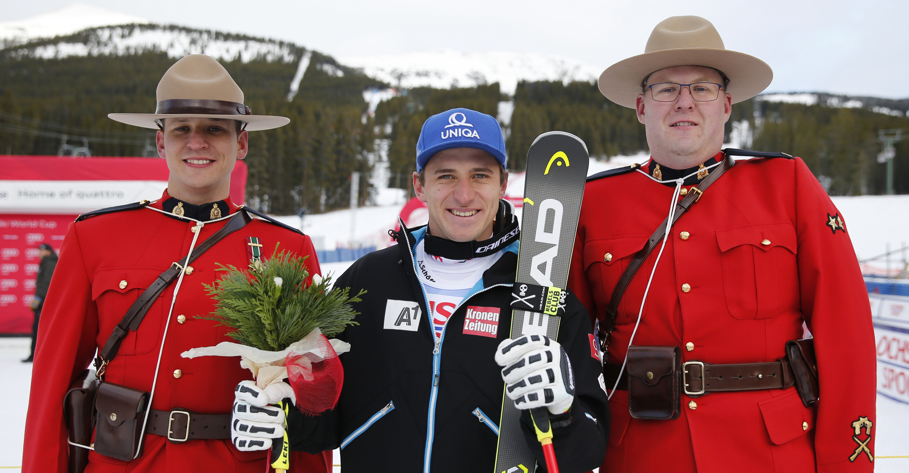 Skifahrer Matthias Mayer und zwei kanadische Mounties bei der Siegerehrung in Lake Louise
