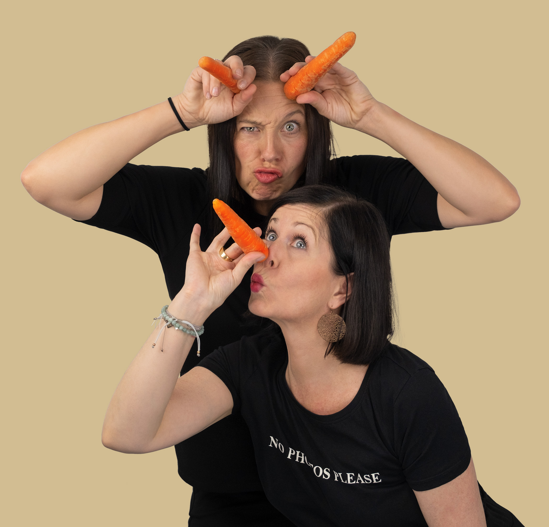 Zwei Frauen mit Karotten auf Stirn und Nase