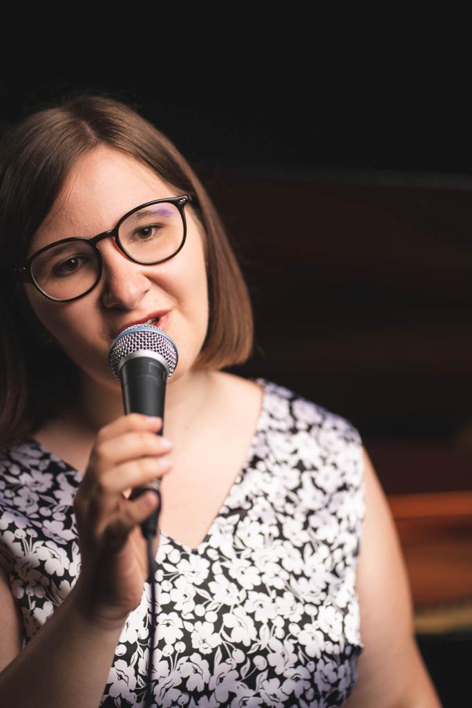 Frau singt ins Mikrofon