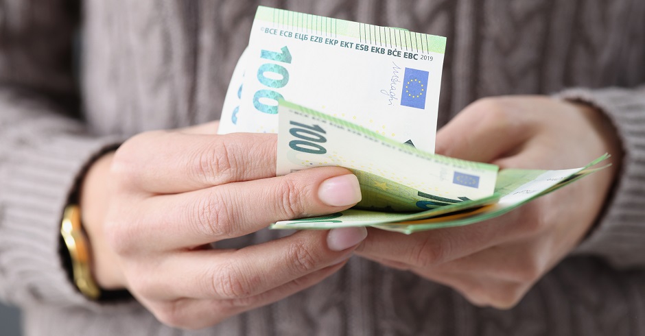 Eine Großaufnahme von Händen, die mehrer Hunderteuroscheine hält.