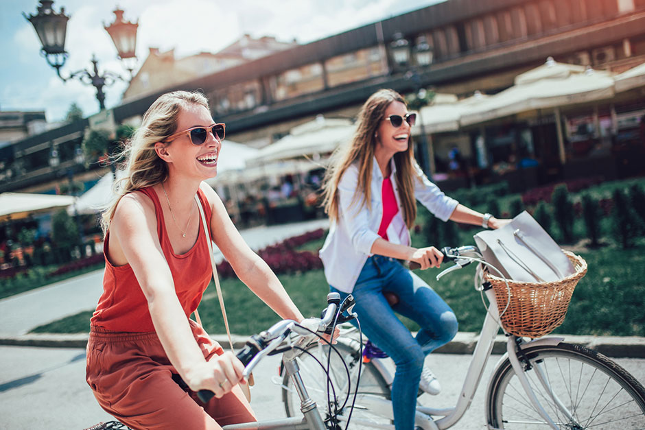 Zwei junge Frauen unterwegs auf dem Fahrrad | Credit: iStock.com/Jovanmandic