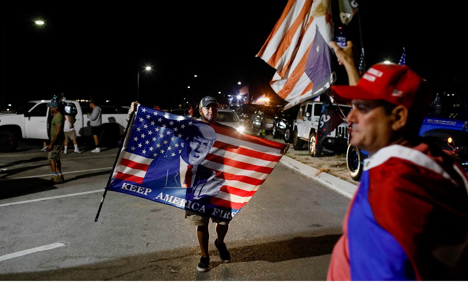 Trump Unterstützer mit Fahnen und Bannern nachts vor seinem Haus