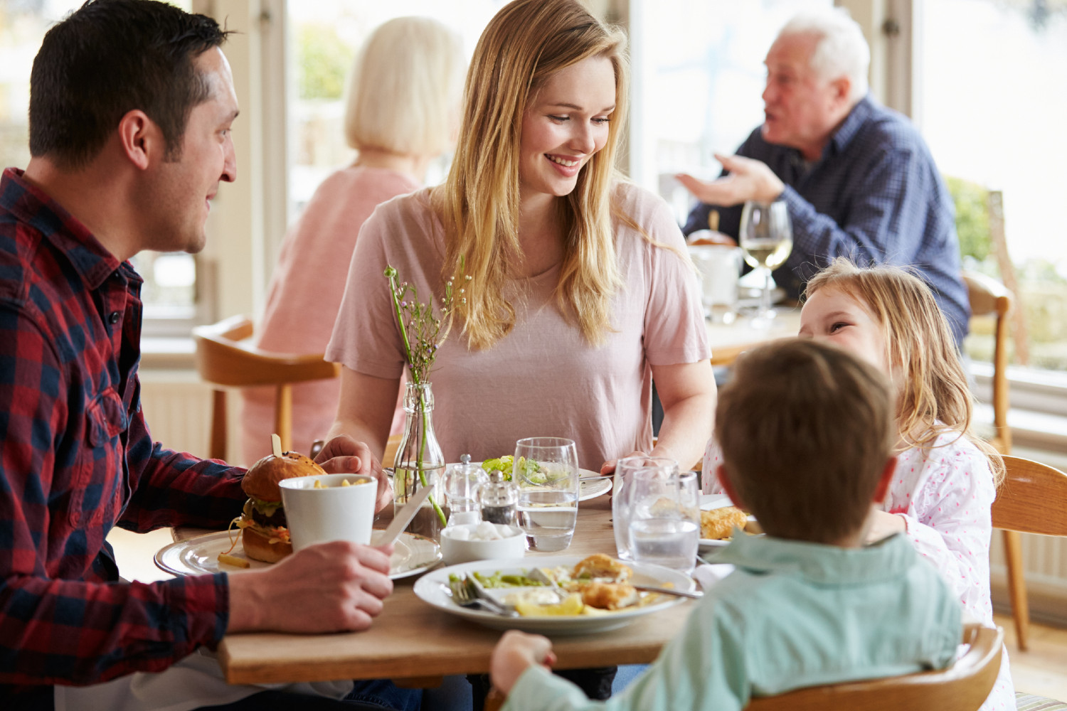 Familie sitzt zusammen und isst | Credit: iStock.com/monkeybusinessimages