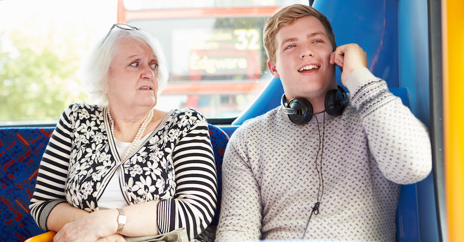 Ältere Frau und junger Mann sitzen im Bus | Credit: iStock.com/monkeybusinessimages