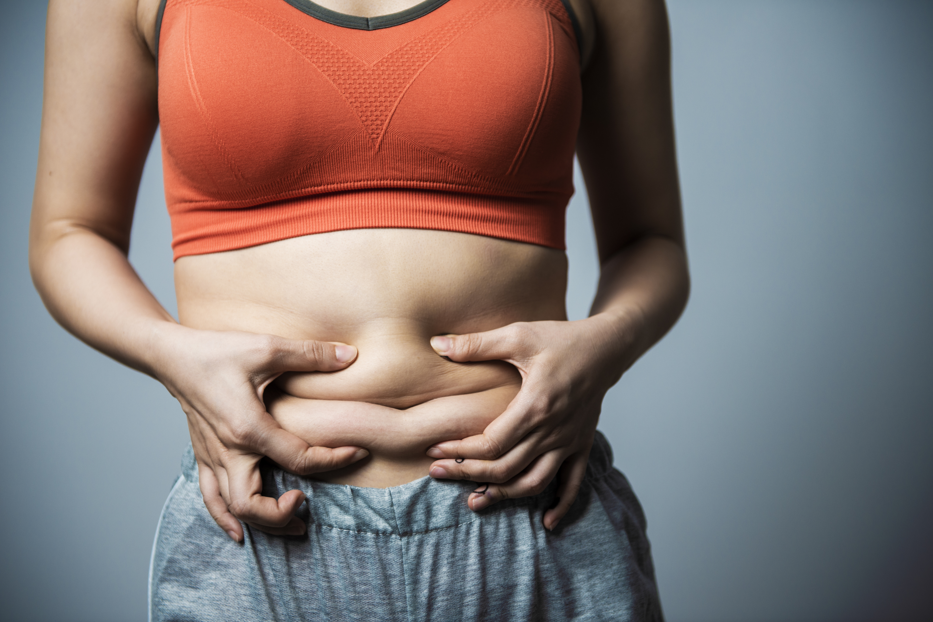 Frau begutachtet ihr Bauchfett. | Credit: iStock.com/ shih-wie