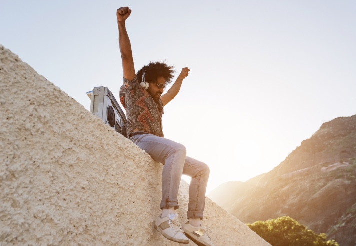 Sommer im Süden: Junger Mann hört Musik. | Credit: iStock.com/DisobeyArt