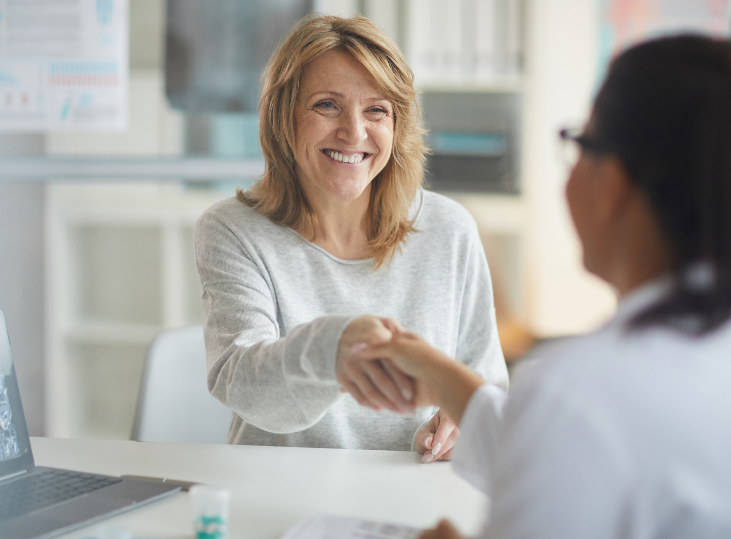 Frau schüttelt anderer Frau die Hand | Credit: iStock.com/AnnaStills