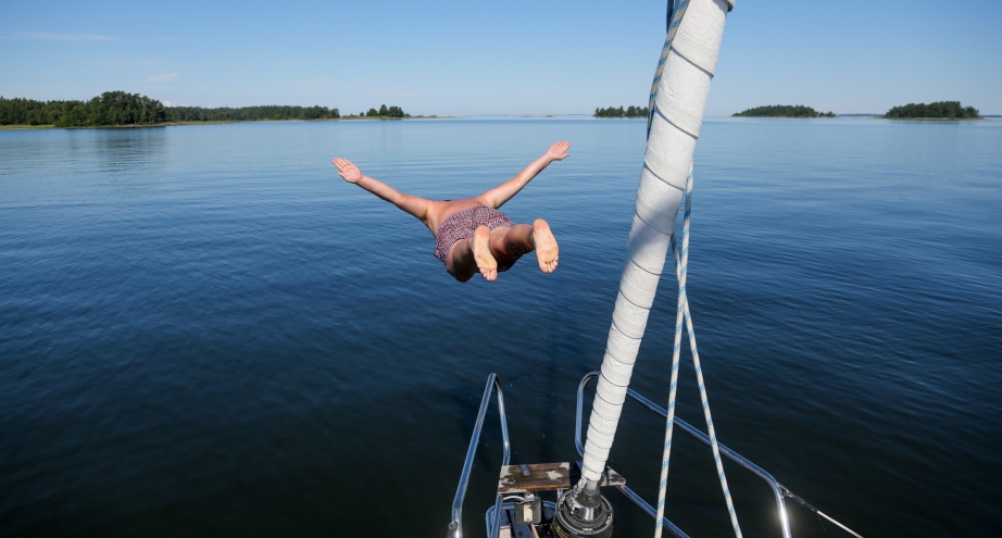 Mann springt von Boot in Vänern See in Schweden. | Credit: unsplash