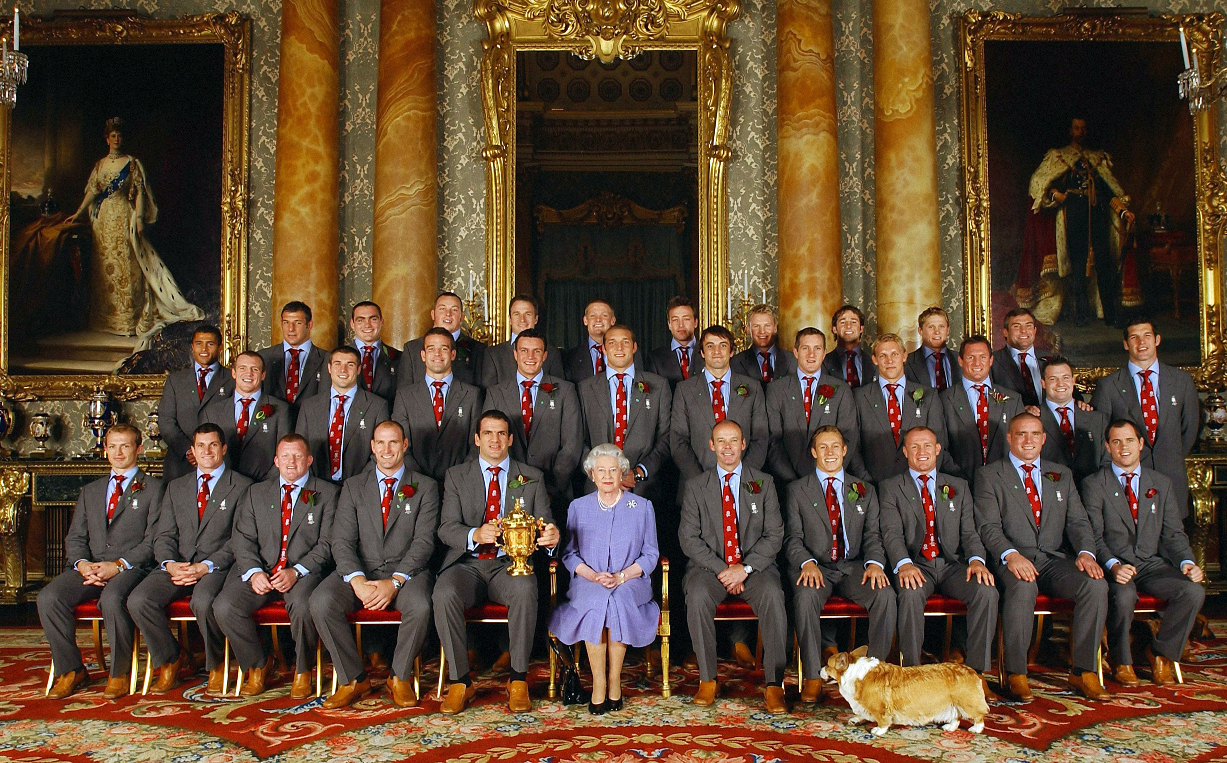 Die Queen mit dem Rugby Nationalteam und einem Corgi