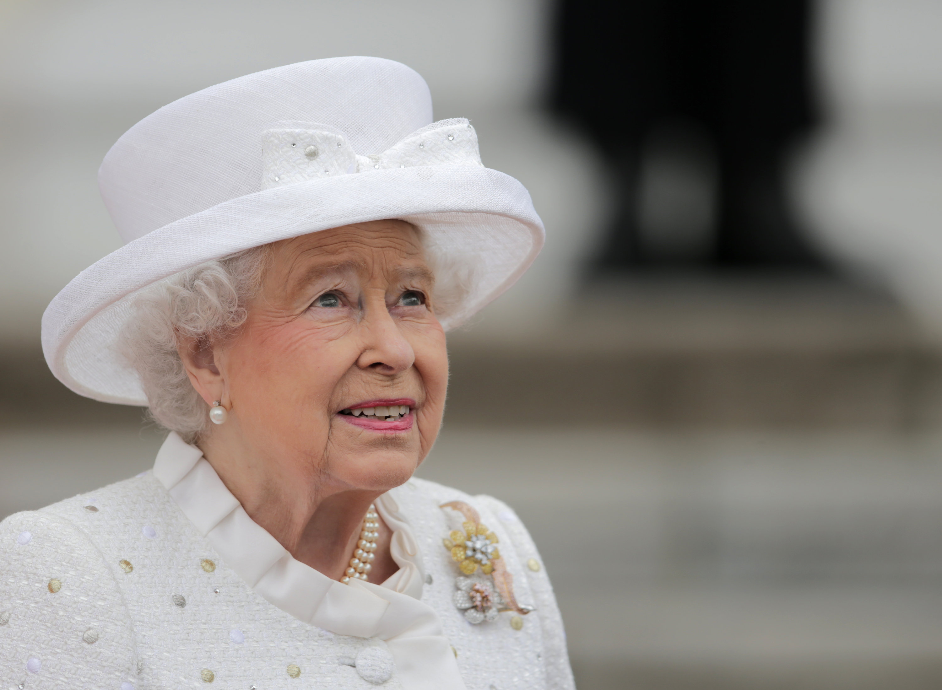 Die Queen im weißen Kostüm mit weißem Hut