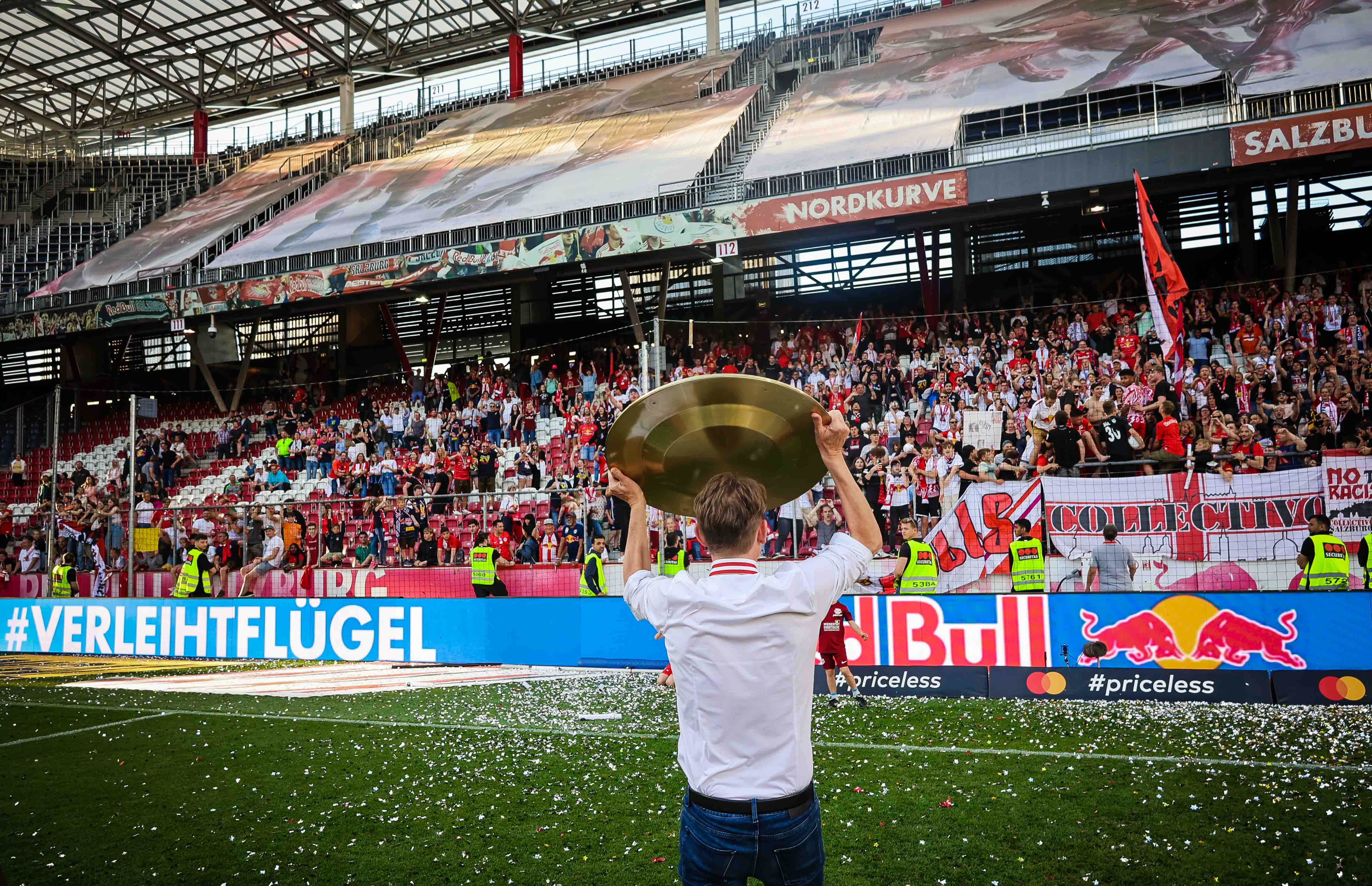 Christoph Freund von  hinten, er zeigt die Meisterschale in Richtung der Fans.