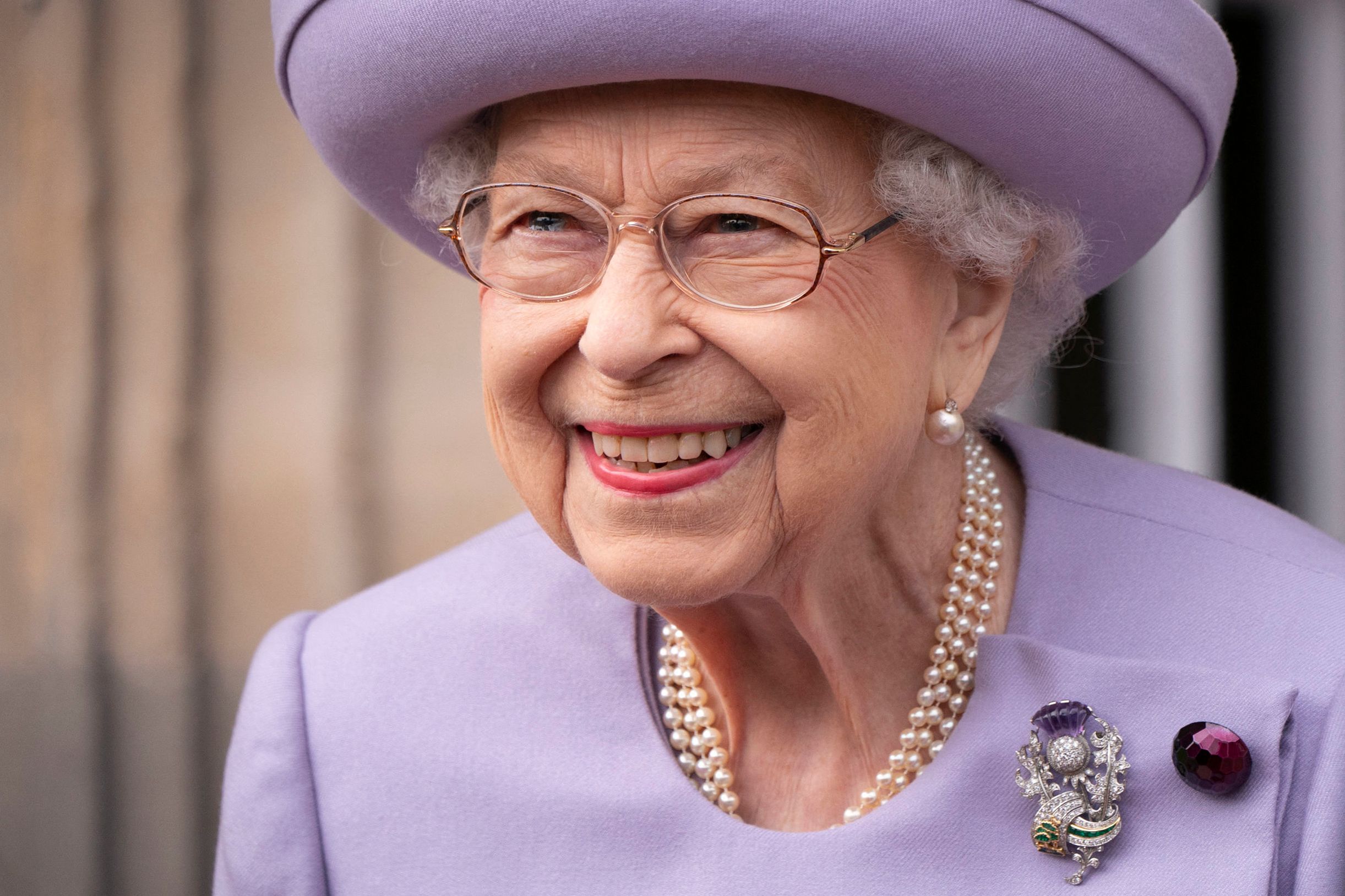 Queen Elizabeth II. in einem lila Kostüm