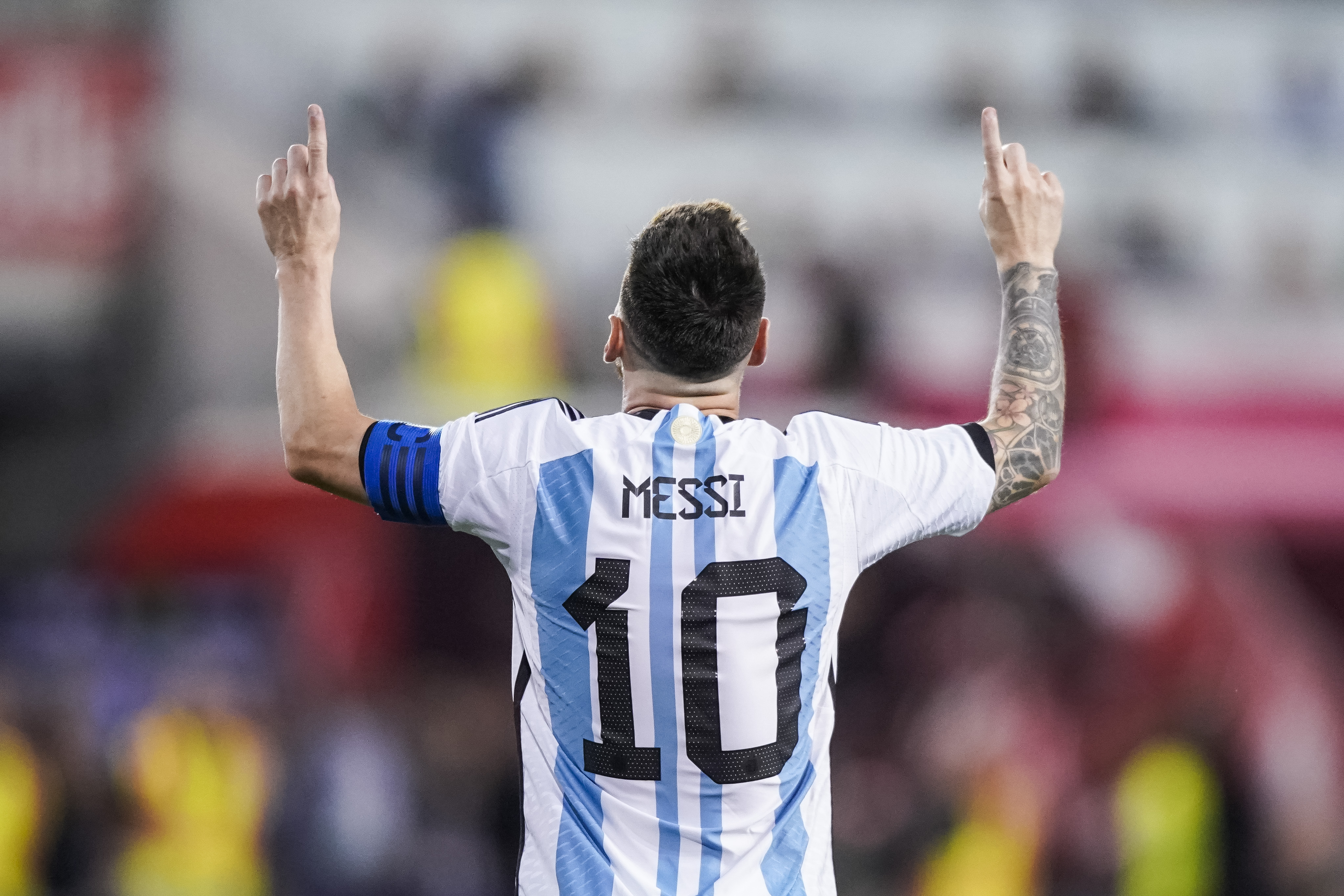 Rückenansicht von Lionel Messi im Dress der argentinischen Nationalmannschaft, der mit beiden Zeigefingern himmelwärts deutet